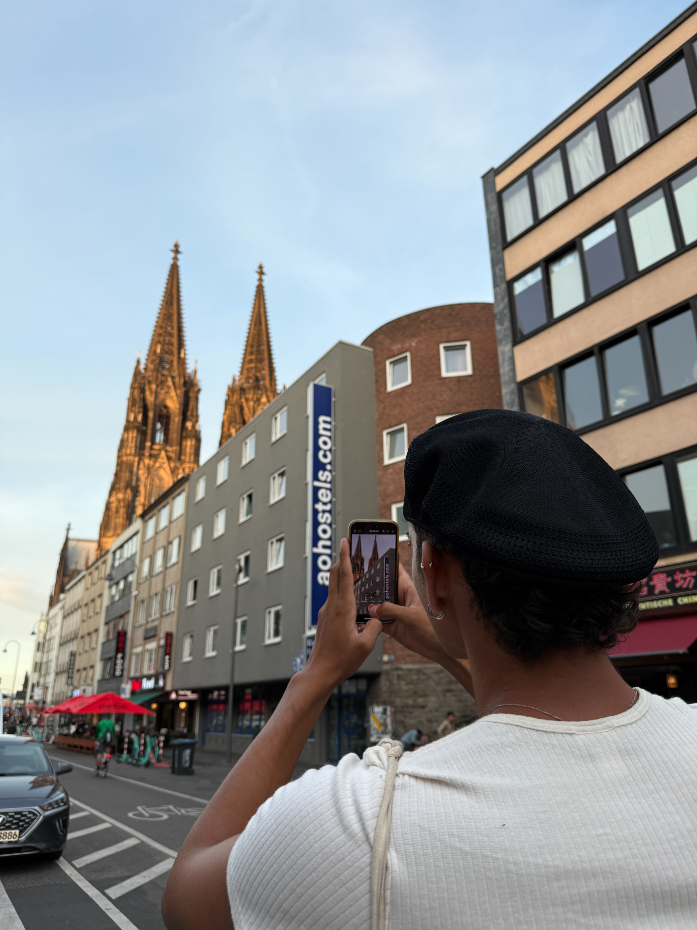 Creator framing a shot of Cologne Cathedral next to an a&o Hostels building